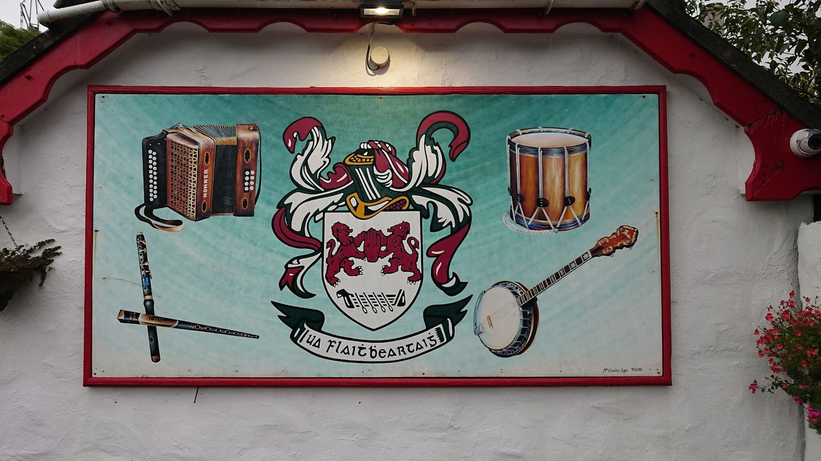 The painted sign at O'Flaherty's — accordion, bodhrán, banjo and tin whistle